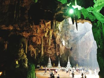 People in illuminated tunnel at night