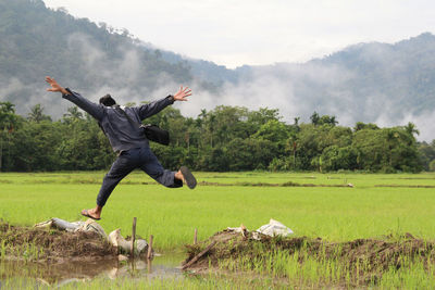 Full length of man jumping over lake