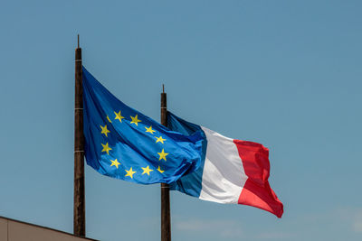 Low angle view of flag against blue sky