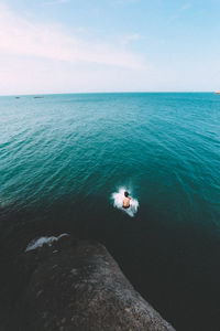 High angle view of shirtless man jumping in sea