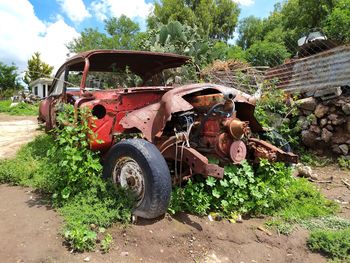 Abandoned truck on field against sky