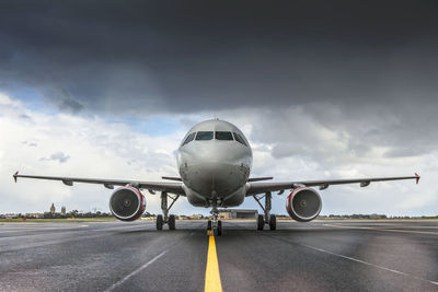 Airplane on runway against sky