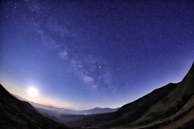 Scenic view of mountains against sky at night