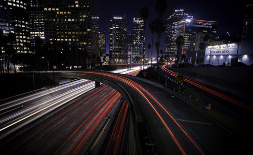 High angle view of illuminated street amidst buildings at night