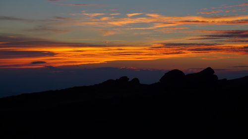 Scenic view of silhouette mountains against sky during sunset