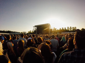 Crowd at music concert against sky