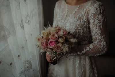 Midsection of woman holding rose bouquet