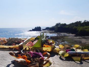 Panoramic shot of fruits on table by sea against sky