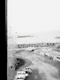 Close-up of wet glass window against clear sky