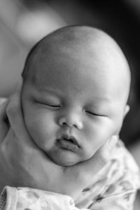 Close-up of hand holding baby sleeping