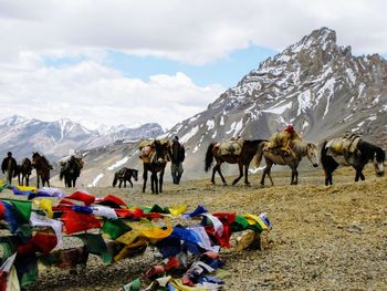 View of people on snow covered mountain against sky