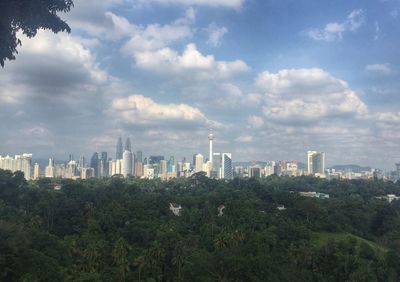 View of cityscape against cloudy sky