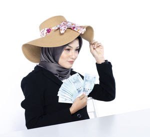 Portrait of woman wearing hat against white background