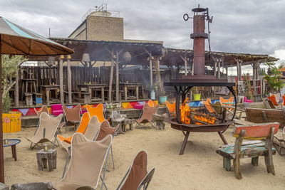 Chairs and tables at restaurant against buildings