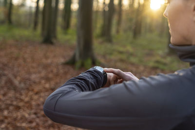 Midsection of man on field in forest