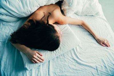 High angle view of woman sleeping on bed