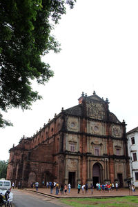 People in front of historic building against clear sky