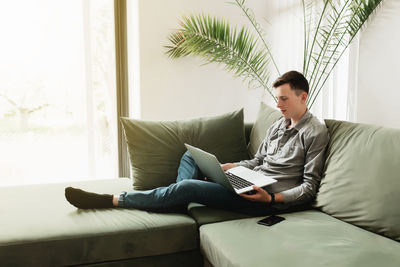 Young man sitting on sofa