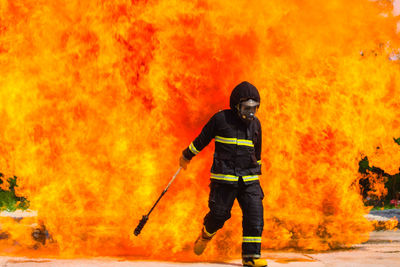 Firefighter walking against fire