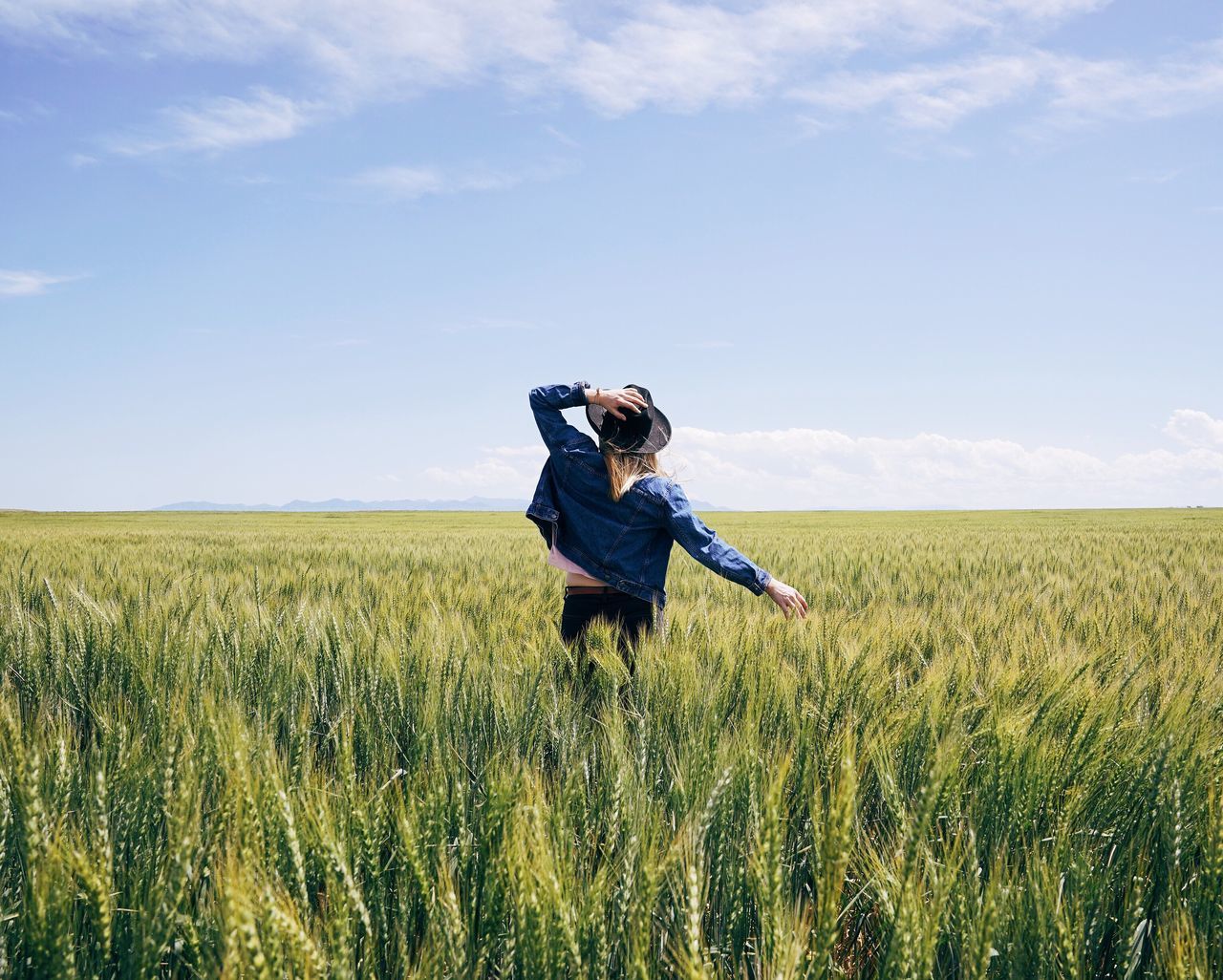 field, growth, one person, crop, rural scene, sky, agriculture, blue, farm, nature, beauty in nature, landscape, outdoors, real people, cereal plant, day, young adult, one young woman only, scarecrow, wheat, people, adults only, adult