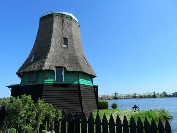 Low angle view of windmill against clear blue sky