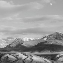 Scenic view of snowcapped mountains against cloudy sky