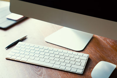 High angle view of keyboard and mouse by desktop pc on desk