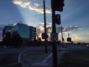 Road sign on street in city against sky