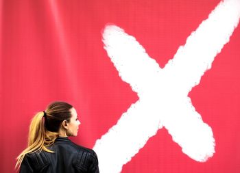 Portrait of woman against red wall