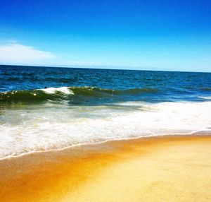 View of calm beach against blue sky