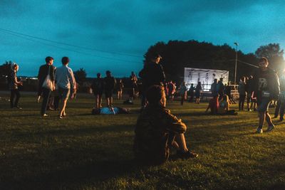 Group of people standing on grassy field