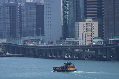 Ship in sea against buildings in city
