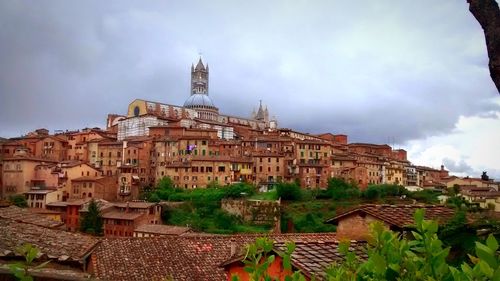 Buildings against cloudy sky