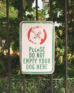 Close-up of warning sign against trees