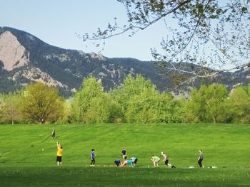 People playing soccer on field against sky