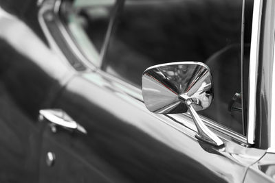 Rear view mirror of classic car in monochrome