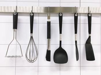 Close-up of kitchen utensils hanging on rack 