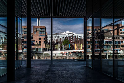 Buildings against sky seen through glass window