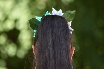 Rear view of woman with ponytail against trees