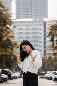 Thoughtful young woman standing on street in city