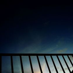 Low angle view of railing against sky at night