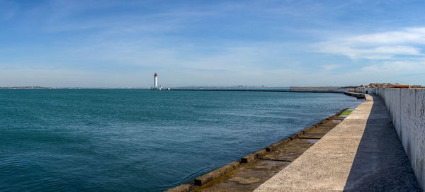 Lighthouse at the entrance to the harbor of odessa seaport, on a sunny summer day