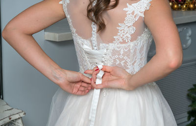 Midsection of bride dressing up during wedding