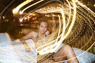 Portrait of young man with light trails at night