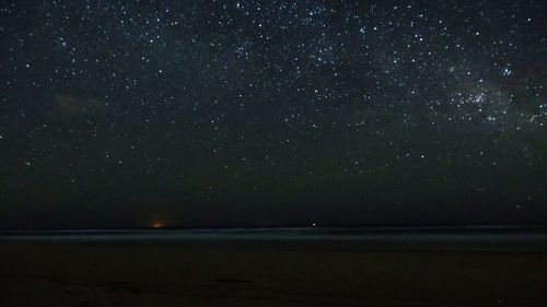 Scenic view of sea against star field at night