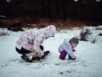Girl playing in snow on field