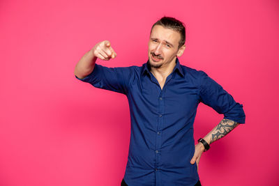 Smiling young man standing against red background