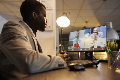 Side view of man using laptop at home