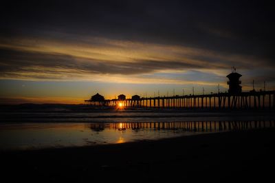 Huntington beach pier by sea against sky during sunset