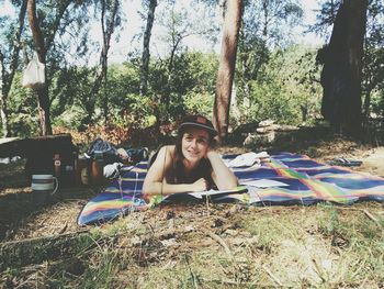 Portrait of young man sitting on tree stump